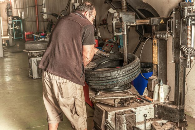 Male mechanic conducting tire repair